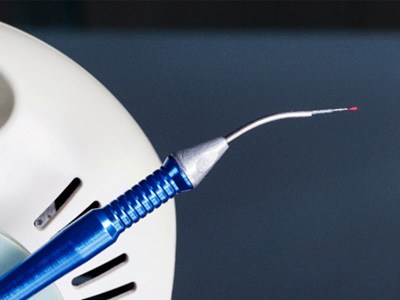Close-up of a dental laser with blue handle