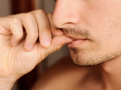 A man biting one of his fingernails 