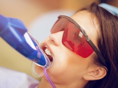 Young woman getting fluoride treatment from dentist