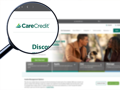 Magnifying glass zooming in on CareCredit logo on laptop screen