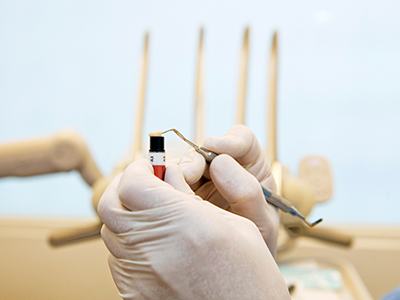 a dentist holding a tube of composite resin