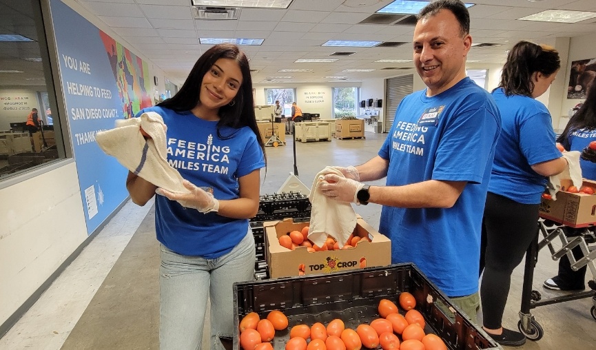 Two team members washing oranges