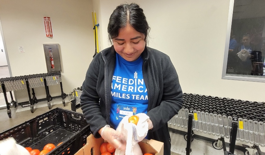 Team member drying off a fruit with a towel