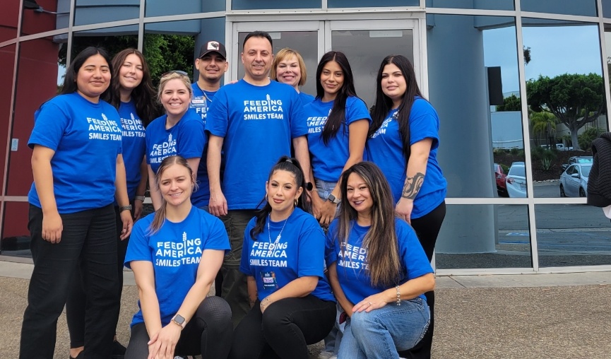 Entire dental team posing in front of Feeding America building