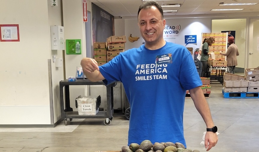 Dental team member Sean smiling and pointing to box of vegetables