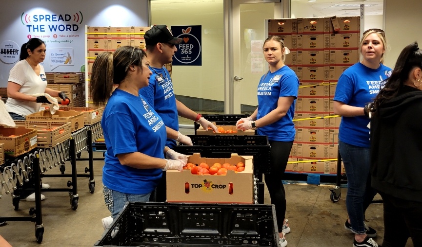 Volunteers sorting fruits and vegetables into boxes
