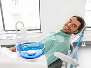 Man leaning back in dental chair and smiling