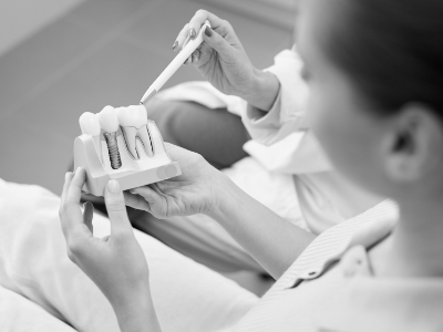 Dentist showing a patient a model of dental implants in Encinitas