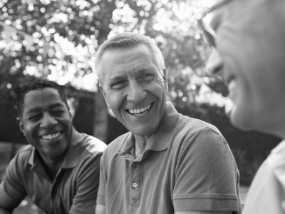 Three men laughing together outdoors