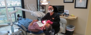 Dental team member looking up from patient while providing dental services in Encinitas