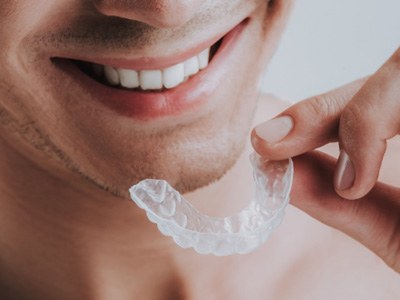 A man holding a transparent mouthguard 