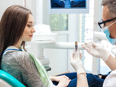 A dentist explaining implant treatment to a patient