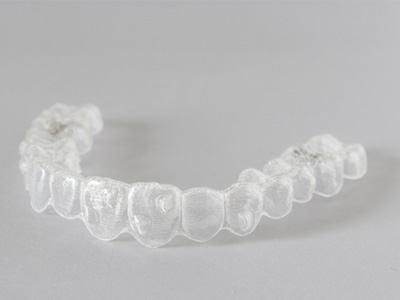 Closeup of clear aligner on grey table