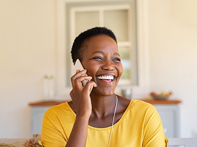 Woman smiling while talking on phone at home