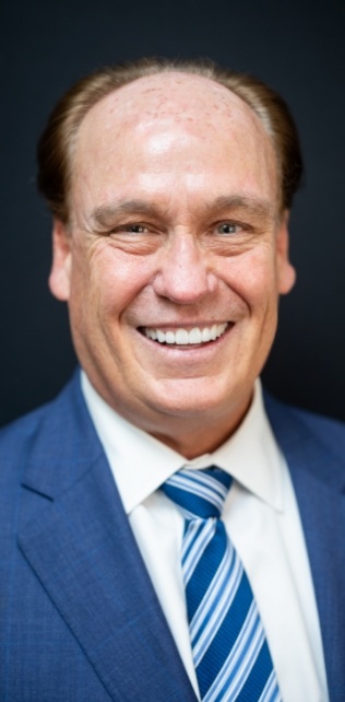 Doctor McElroy smiling in dark blue suit