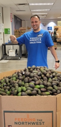 Dental team member standing in front of large box of vegetables