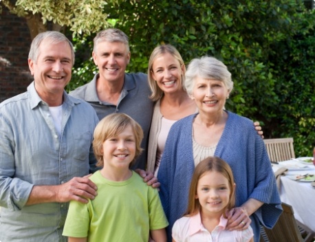 Three generations of a smiling family in their backyard