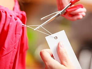 Person using scissors to remove clothing tag