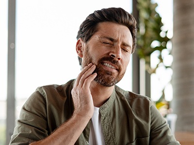 Woman smiling while holding mirror in treatment chair