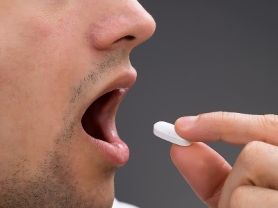 Close up of person taking white pill