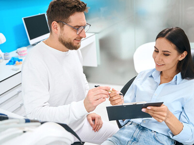 woman signing dental paperwork